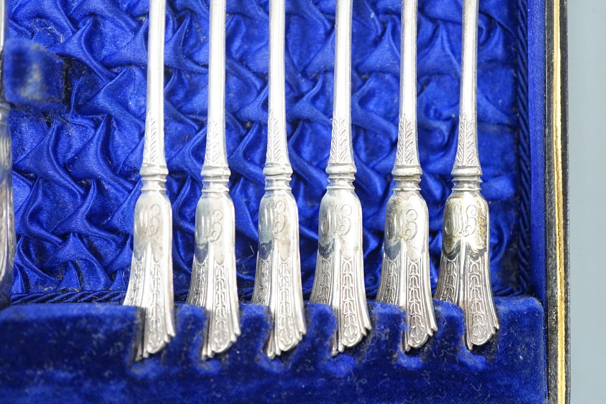 A cased set of six silver bean end coffee spoons, two other sets of six teaspoons and a pair of silver sugar tongs.